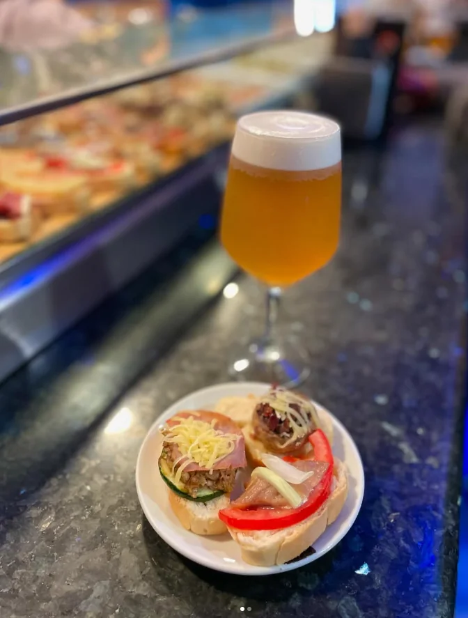 Caña de cerveza con un pincho en la barra